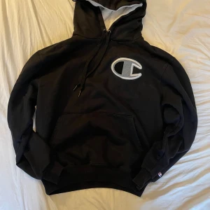 Svart hoodie från Champion - Champion Hoodie (M)  Chest - 55 cm (22 inch Length - 60 cm (23 inch Hem - 40 cm (16 inch Shoulders - 50 cm (21 inch Sleeve - 57 cm (23 inch 