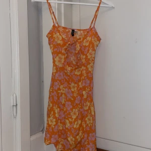 Knyt klänning - Kort klänning med knyt fram och blommigt mönster. Dragkedja på sidan🩷