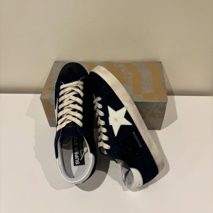 Golden goose skor - Säljer ett par eftertraktade mörkblåa golden goose i storlek 42, skorna är helt nya! Bara skriva till oss vid minsta fråga eller fundering. Priset kan diskuteras vid snabb affär. Kvitto finns!✅