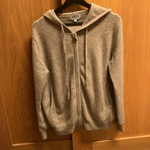 Kashmir  - Säljer en supermjuk beige hoodie i 100% kashmir från ROVOIR. Den har dragkedja framtill och en skön huva. Perfekt för kyliga dagar när du vill ha något bekvämt och stilrent. Passar bra till både jeans och mjukisbyxor.