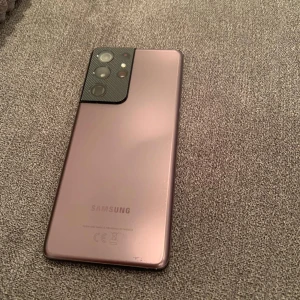 Samsung Galaxy S21 Ultra (512 gb) - Säljer en Samsung Galaxy S21 Ultra i en elegant roséguld färg. Telefonen har en stor skärm och flera kameror på baksidan för fantastiska foton. Perfekt för dig som vill ha en kraftfull smartphone med stilren design. Hör av dig vid intresse!