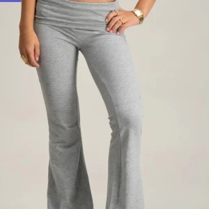 Grå yoga pants  - Snygga grå mjukisbyxor med bootcut-stil. Perfekta för en avslappnad look med en bekväm passform. Byxorna har en låg midja och är tillverkade i mjukt material för extra komfort.