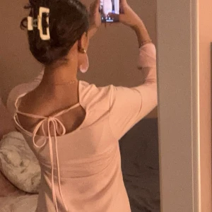 Rosa klänning med öppen rygg - Säljer en söt ljusrosa klänning med långa ärmar och knytband i ryggen. Endast använd 2 gånger💕💕