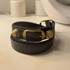 Balenciaga armband - Säljer mitt balenciaga armband i svarta och guld pgd kommer inte till användning. Super bra skick utan några repor eller skador 
