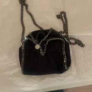 Mörkblå axelväska från Stella McCartney - SkitSnygg mörkblå Tiny Falabella väska från Stella McCartney.Väskan kommer med en dustbag men har tyvärr inte kvar kvittot. skriv för fler bilder eller frågor. Den är i väldigt bra skick utan några defekter.
