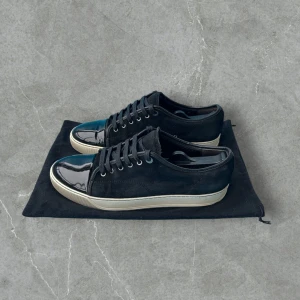 Lanvin Cap Toe Svart 45 - Svart mocka och glansig cap toe - sparsamt använda och i bra skick förutom mindre defekt - storlek UK10 (passar 45)  - nypris ~5000kr - dustbag medföljer vid köp - hör av dig vid frågor!