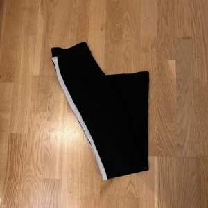 Bootcut byxor - Bootcut byxor från Gina Tricot, vita ränder på sidorna. Storlek XS. Passar mig som är 158cm lång 