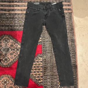 Svarta Replay anbass hyperflex jeans  - Snygga svarta jeans från Replay, modell Anbass. De har en slim passform och är tillverkade i ett bekvämt denimtyg. Perfekta för en stilren look. De har krymt lite på längden så skulle säga de är runt 30L