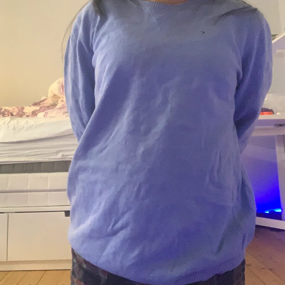 Säljer en stilren blå tröja från Tommy Hilfiger. Tröjan har en rund halsringning och långa ärmar. Perfekt för en simpel still eller ha hemma. Liten fläk på långärmad men syns knappt!. Neuletakit & Villapaidat.