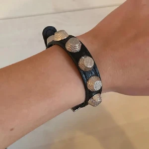 Svart armband med silvernitar - Snyggt svart armband med stora silverfärgade nitar. Väldigt likt baleziaga armbandet! Justerbart