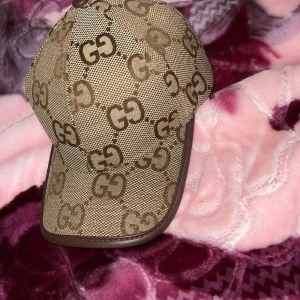 Beige keps med GG-mönster - Snygg gucci beige keps med det ikoniska . Perfekt för att ge din outfit en lyxig touch. 