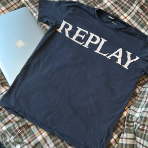 Svart t-shirt från Replay - Snygg svart t-shirt från Replay med stort vitt tryck på framsidan. Den har en klassisk rund hals och korta ärmar. Perfekt för en avslappnad stil.