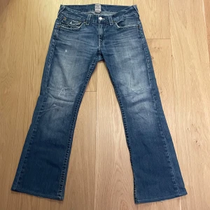 True religion jeans - Bootcut trues, reparerade på knäna och hälen. W:  42cm L: 104cm benöppning: 25cm