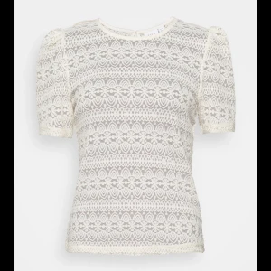 Vit spetsblus från VILA - Säljer en elegant vit spetsblus från VILA. Blusen har korta ärmar och ett vackert spetsmönster som ger en romantisk känsla. Perfekt för att lyfta vilken outfit som helst. 💫endast använd en gång 