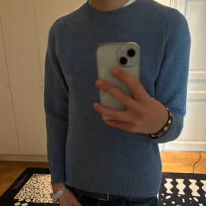 Stickad tröja - Säljer en snygg blå stickad tröja från Uniqlo. Den är perfekt för kyliga dagar med sin mjuka och varma känsla. Tröjan har långa ärmar och en klassisk rund halsringning. Passar både till vardags och lite finare tillfällen. 🧶💙