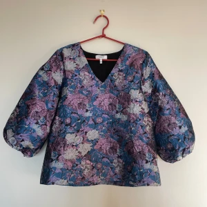 Blus med puffärm  - opp/blus med puffärm och skimrande tyg. Tyget är lite tjockare i kvaliteten vilket gör att den håller formen väldigt snyggt även på. Mycket fint skick, endast använd 1 gång! Se även mina andra annonser, 3 för 2 på allt! ✨