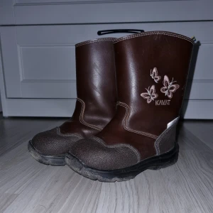 Bruna boots från Kavat - Säljer ett par bruna boots från Kavat med broderade fjärilar på sidan. De har en robust sula och är fodrade för extra värme. Perfekta för kyligare dagar.