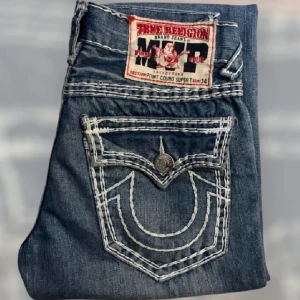 True Religion MVP Point couro super t jeans - Fat stitch True Religion jeans, MVP Point couro super t. Lite mer baggy är Ricky. Nästan som nya bortsett från den klippta sömmen som visas på bild. Saknar dock storleksmärkning, jämfört med andra byxor säger jag storleken är W32.