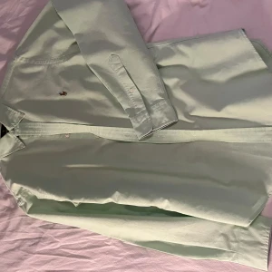 Grön skjorta från Ralph Lauren - Snygg grön skjorta från Ralph Lauren i slim fit. Skjortan har långa ärmar och är dekorerad med det klassiska broderade logotypen på bröstet. Perfekt för en stilren look.