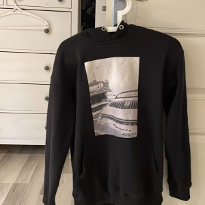 Svart hoodie från BLing LUCID - Säljer en svart hoodie från BLing LUCID med en snygg bilf på framsidan av tröjan .. Hoodien har en klassisk design med långa ärmar och en rymlig huva. Perfekt för en avslappnad stil. Nypris 599-699 passar 160-175