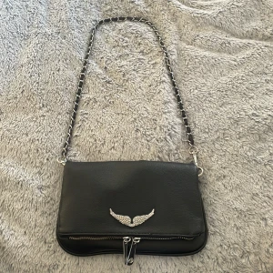 Zadig Voltaire väska - Säljer min fina Zadig Voltaire väska. Den är super söt till alla typer av outfits och den har bra med utrymme tycker jag. Man kan ändra band om man vill ha längre (se bild). Inga tecken på användning finns. Priset kan diskuteras💗