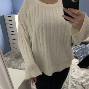 Vit stickad tröja - Mysig vit stickad tröja i oversized modell. Perfekt för kyliga dagar med sitt ribbade mönster och långa ärmar. Den är superbekväm och passar till både jeans och leggings. Ett måste i garderoben för höst och vinter!