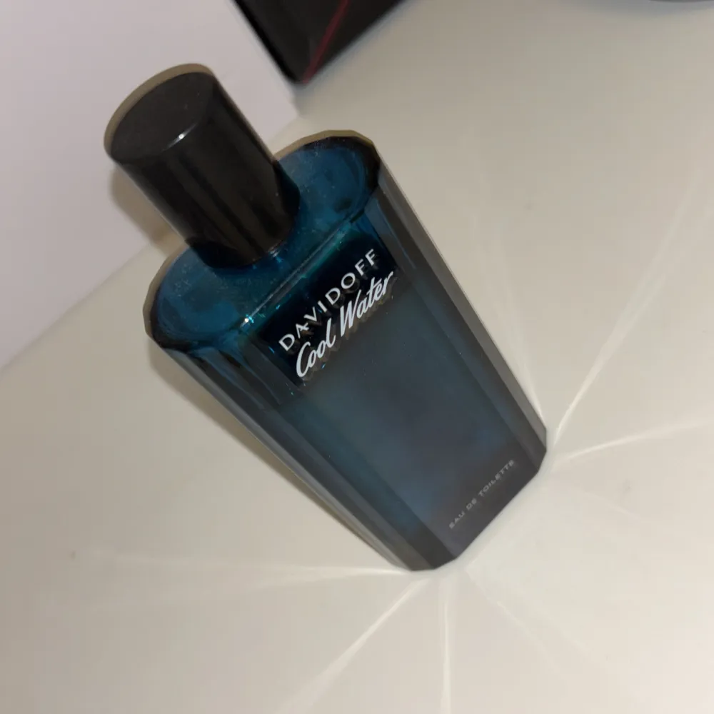 Säljer en flaska Davidoff Cool Water Eau de Toilette. Flaskan är stilren och blå med svart kork, perfekt för den som gillar fräscha och marina dofter. Passar både till vardags och fest. En klassiker som aldrig går ur tiden!. Parfym.