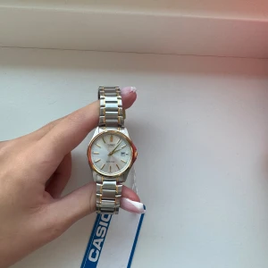 Silver klocka , guld detaljer - Säljer denna silver klocka, den har guld detaljer runt hela klockan. Klockan är helt oanvänd och har fortfarande sina etiketter på, SOM NY!   Säljer pga flytt