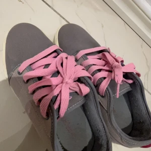 Grå sneakers med rosa snörning rullskor  - Säljer ett par grå sneakers i mycket bra skick med rosa snörning. Med rull som man kan skeata me, man kan ta bort rullarna så att de ser ut som vanligt skor. Köpte dom när de va tvär populära för 1000kr.