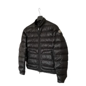 Svart dunjacka från Moncler - Säljer en snygg svart dunjacka från Moncler i mycket bra skick. Jackan är quiltad och har en dragkedja framtill. Perfekt för höst och vinter med sin varma och stilrena design. Den har långa ärmar och Monclers logga på ärmen. Passar både till vardags och lite finare tillfällen. Jackan är i storlek 2. Hör gärna av er om ni har några frågor!