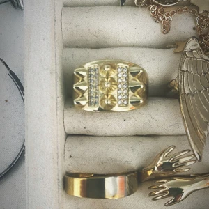 Guldfärgad ring med nitar och stenar - Säljer en cool guldfärgad ring med nitar och glittrande stenar. Ringen har en öppen design vilket gör den justerbar i storlek. Den liknar Edblad ringen väldigt mycket💕💕