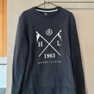 Marinblå tröja från Henri Lloyd - storlek M - Säljer en stilren marinblå tröja från Henri Lloyd med tryck framtill. Tröjan är i mycket bra skick och har långa ärmar. Perfekt för både vardag och lite finare tillfällen. Passar bra till jeans eller chinos!