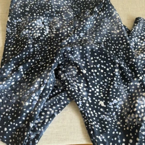 Mönstrade leggings från Röhnisch - Säljer ett par snygga leggings från Röhnisch i storlek S. De är svarta med ett coolt prickigt mönster i vitt och grått. Perfekta för träning eller en avslappnad dag. Materialet är stretchigt och bekvämt, vilket gör dem idealiska för både gymmet och vardagen.