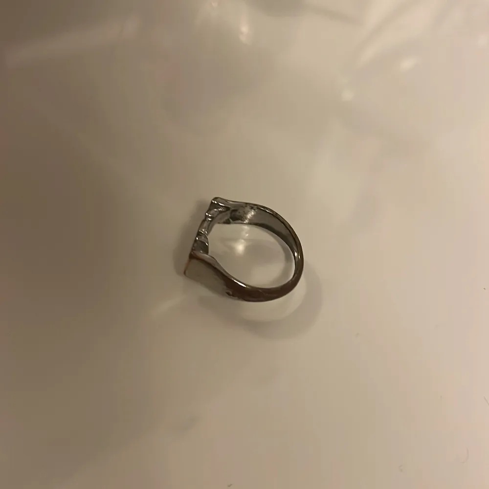 Säljer en stilren och personlig ring i silverfärg med texten 'MOM'. Man kan även vända den så att det står WOW. Den har tappat lite färg . Asusteet.