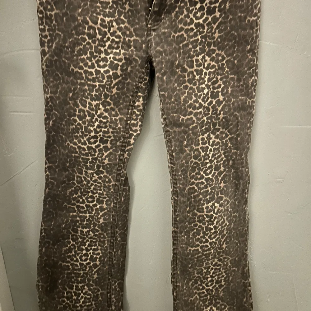 Säljer ett par snygga leopardmönstrade byxor i bootcut-stil. De är perfekta för en utekväll eller när du vill sticka ut lite extra. Byxorna har en normal passform och är i mycket bra skick. De är både bekväma och trendiga! storlek 38 men sitter som en 34/36. Jeans & Byxor.