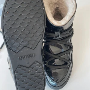 Inuikii skor - Säljer mina svarta glansiga inuikii skor, köpta här på vinted men säljer för att de va för små. Bra skick, de håller kyla och snö väldigt bra då de är ett glansigt material som inte släpper in något. 