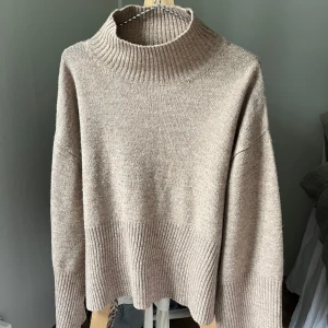 Beige stickad polotröja från Gina Tricot - Säljer en supermysig beige/brun stickad polotröja från Gina Tricot i storlek Xs, passar även S. Tröjan har en lös passform och ribbade detaljer vid ärmslut och nederkant, samt slits på sidorna. Passar perferk för höst och vinter 🤎🍂Nyskick!