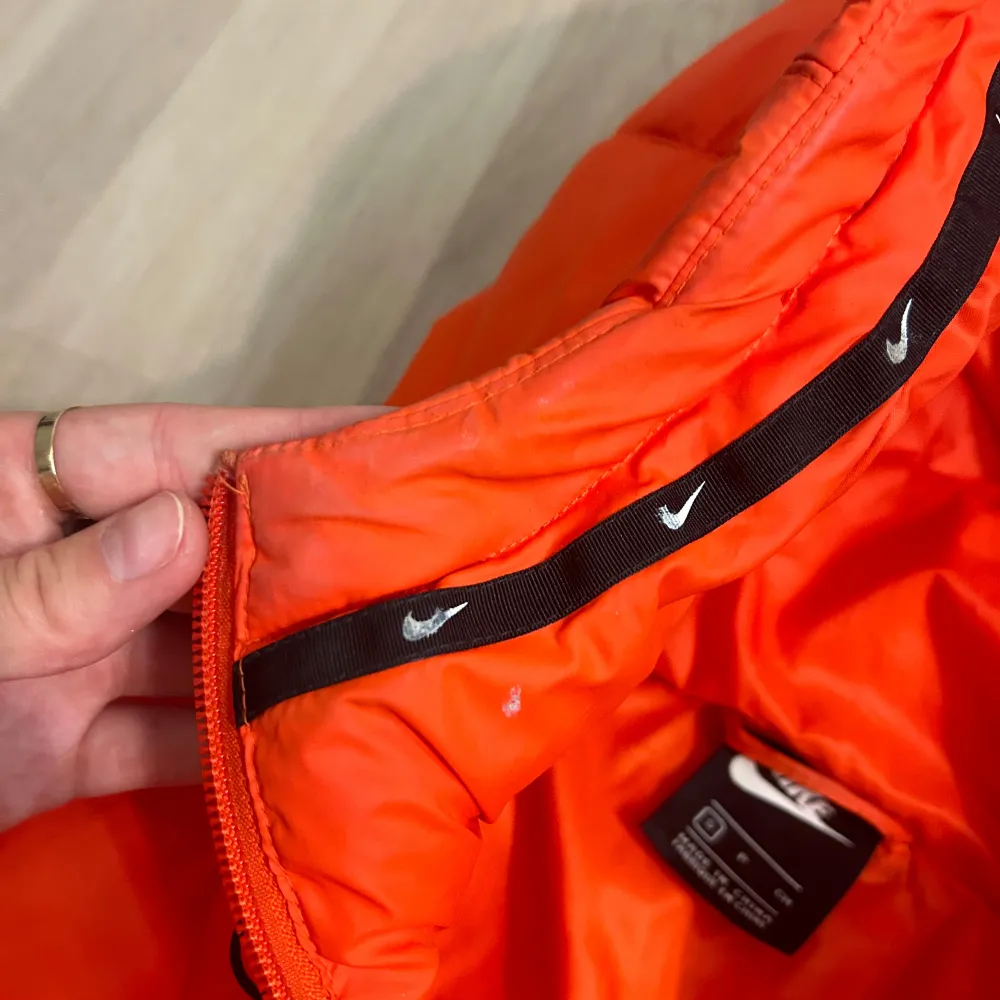 Vinterjacka från Nike i en orange färg. Jackan är använd men är i fint skick, har dock några få sminkfläckar upptill kolla de sista bilderna. . Jackor.