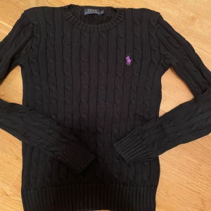 Polo Ralph Lauren tröja  - Ralph lauren tröja, Varm och bekväm tröja i perfekt skick. Storlek är XS och ger en tajt look. Färgen är svart med lila loga. 