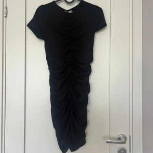Klänning - Säljer den här klänningen från H&M i storlek S. Drapering både fram, bak och på sidorna. Använd en gång.