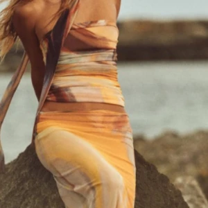 Flerfärgad set från Zara  - Trendig flerfärgad kjol set med ett abstrakt mönster i varma toner.  Settet  är axelbandslös och har en smickrande passform som framhäver figuren. Perfekt som julklapp! Aldrig använd endast testad . Säljer både toppen och kjolen.