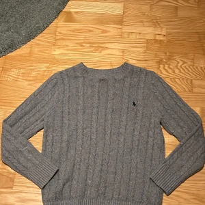 Grå stickad tröja från Ralph Lauren - Säljer en snygg grå stickad Ralph Lauren tröja. Perfekt för kyligare dagar. Hör av er för att diskutera pris.