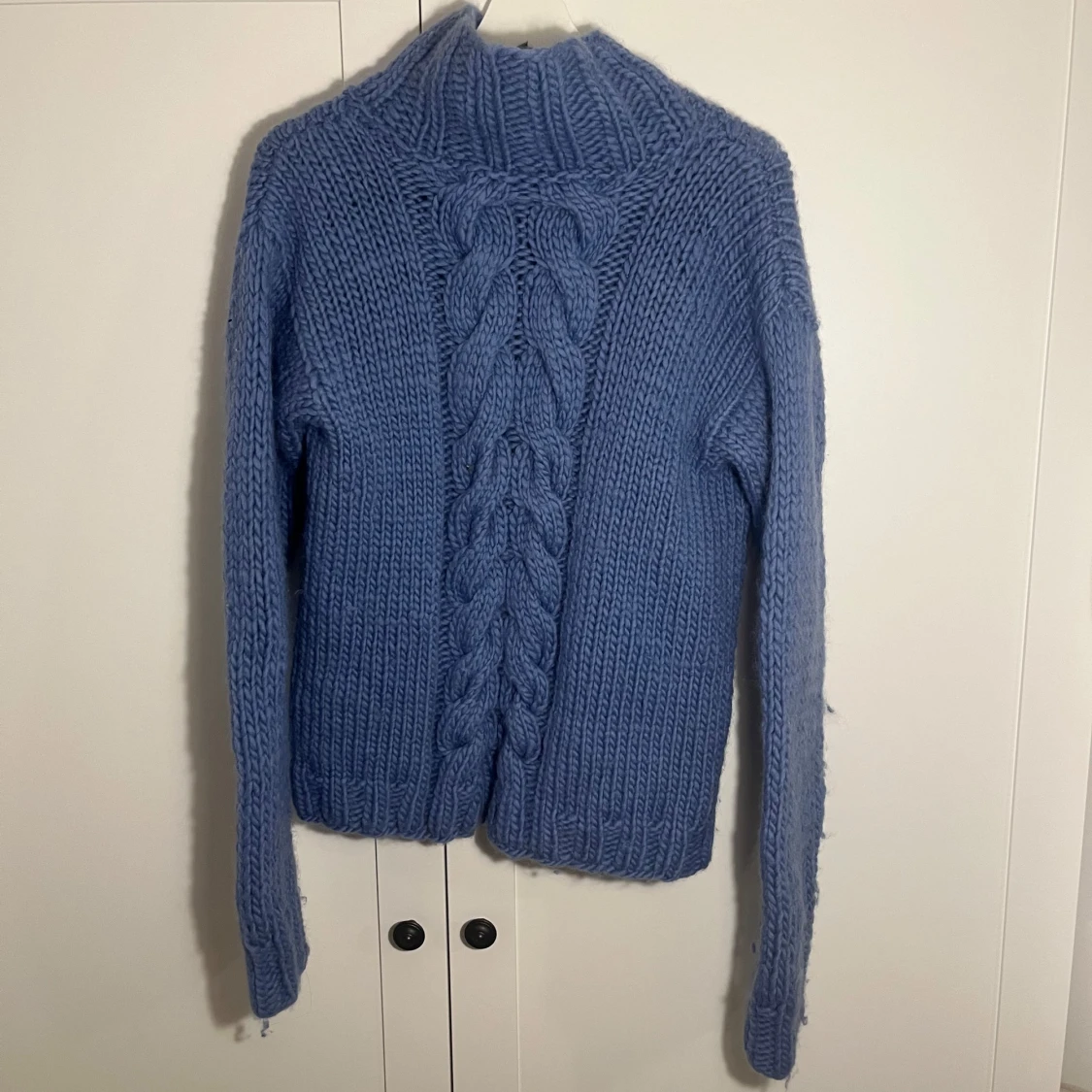 Blå stickad tröja med flätmönster