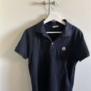 Svart kortärmad pikétröja från Moncler - Snygg svart moncler pikétröja storlek s. Skriv för mer frågor. Den är s men passar storlek m också