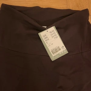 Brun kjol i XS - Snygg  brun kortkjol i en stilren design. Perfekt för att matcha med olika toppar och accessoarer. Kjolen har en enkel och elegant look som passar till många tillfällen.