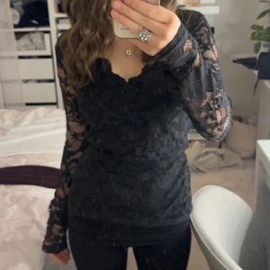 Svart spetsblus - Jättefin svart spetsblus med långärmade genomskinliga ärmar och v-ringad vid halsen.