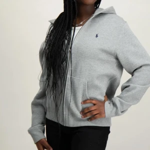 Grå hoodie från Ralph Lauren - Snygg grå hoodie från Ralph Lauren med dragkedja. Mycket bra skick. Nypris 1195 men säljs för 500.