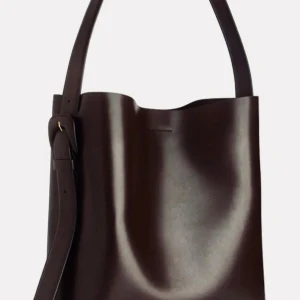 Mörkbrun  axelväska i skinn (TOTE) ARKET - Snygg och stilren brun axelväska i skinn med justerbar axelrem. Perfekt för en chic och minimalistisk look. Väskan har en enkel design utan extra detaljer, vilket gör den tidlös och lätt att matcha med olika outfits. Det får plats med en bärbar dator. OBS: Detta är den största storleken 35X32X13. Skicka prisförslag :)