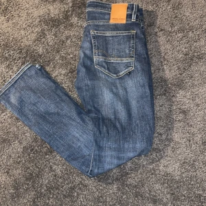 Blå jeans från Jack & Jones - Snygga blå jeans från Jack & Jones med klassisk femficksdesign. De har en straight passform och är perfekta för en avslappnad stil modellen är slim fit 