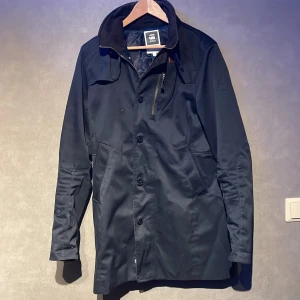 Mörkblå  rock från G-Star Raw - Snygg mörkblå rock från G-Star Raw med knappar och dragkedja. Skick 8,5/10. Storlek M. Modellen på bilden är 167cm lång. Skriv vid minsta fundering!